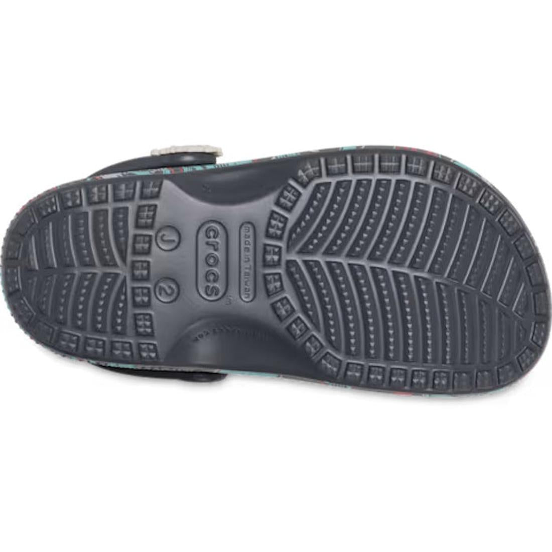 The textured black rubber sole of a Crocs Kids Classic Clog Space Monster Junior Youth, featuring brand details and size markings molded into the center of these water-friendly sandals., 198445574023, 198445574030, 198445574047, 198445574054, 198445574061
