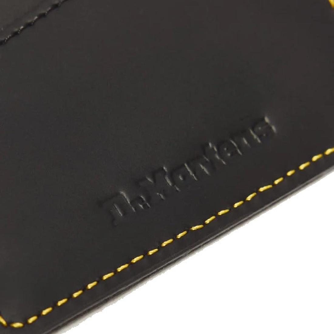 Close-up of the Dr. Martens Cardholder Keyring Black Kiev Leather Bag Charm, showcasing yellow stitching and partially visible embossed Dr. Martens text, with a detachable wrist strap., 190665739787