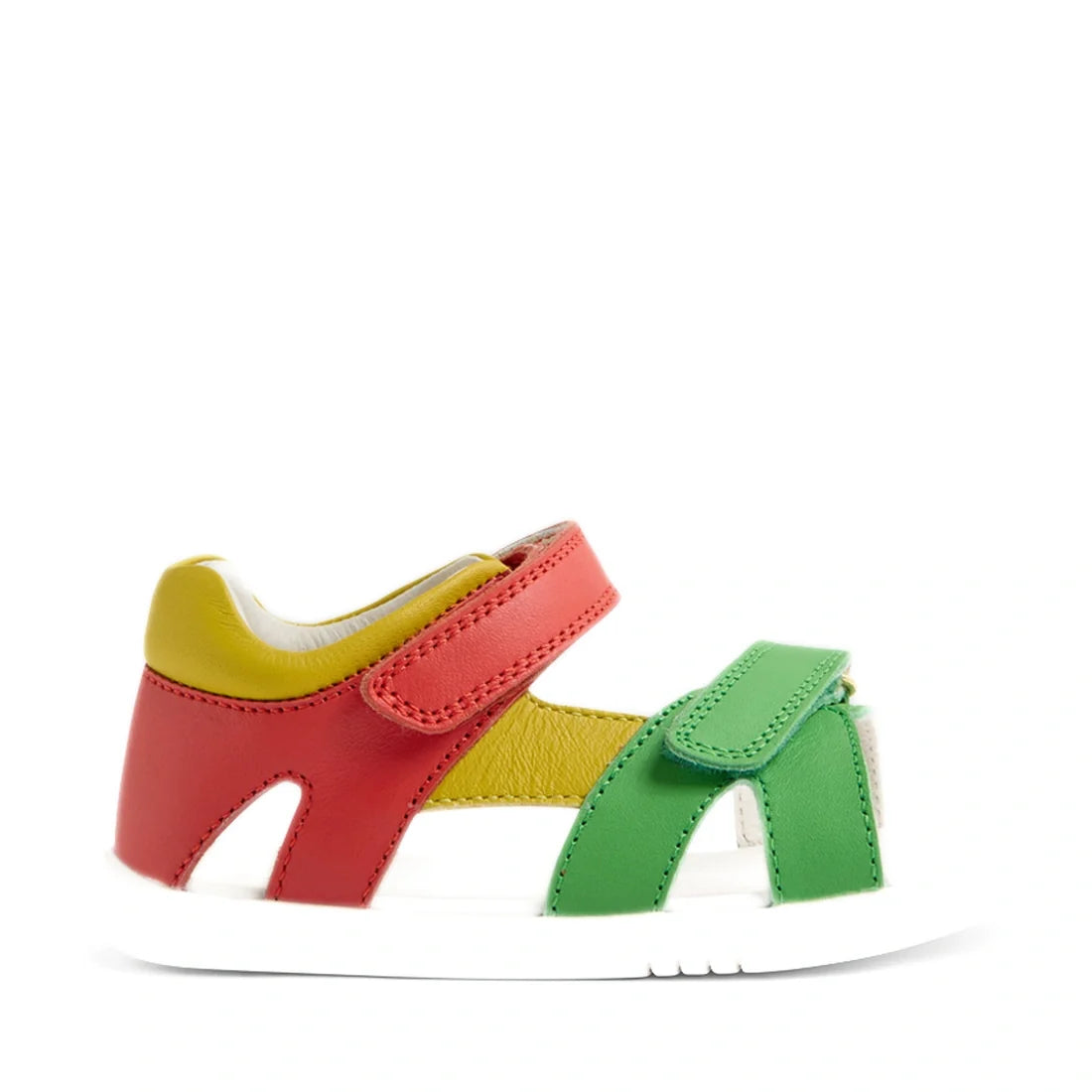 The Bobux IWalk Dune Toddlers Sandal in Grenadine Red features red, yellow, and green leather straps with a white sole and adjustable closures for a secure fit. Shown from the side on a white background, these open-toe sandals combine vibrant style with p