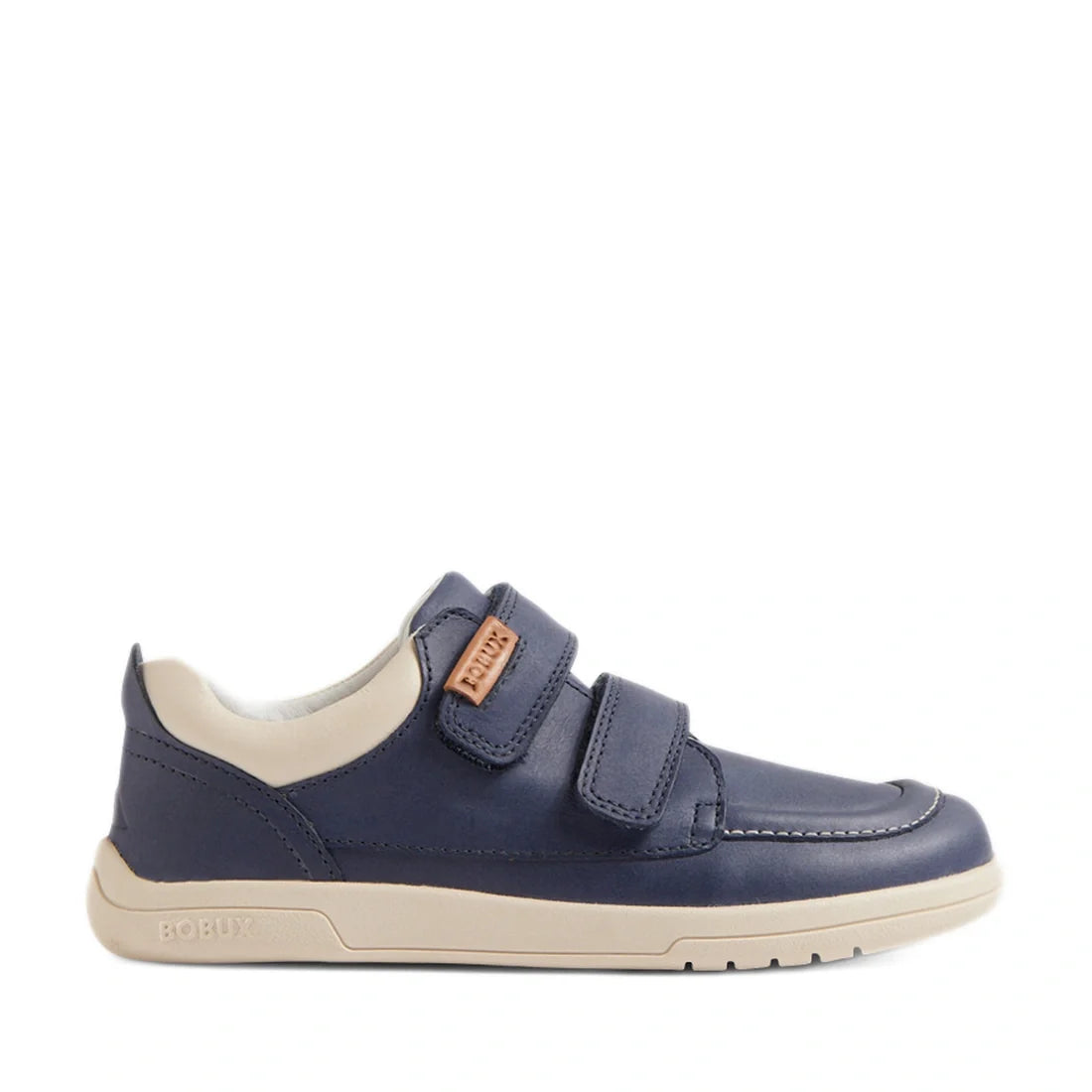 The Bobux Kid+ Plus KP Oakley Leather Sneaker in Vintage Indigo Blue features twin-strap velcro closures, a navy blue and beige leather upper, a beige sole, and a tan label on the side, photographed on a white background., 9420074848284, 9420074848307, 94