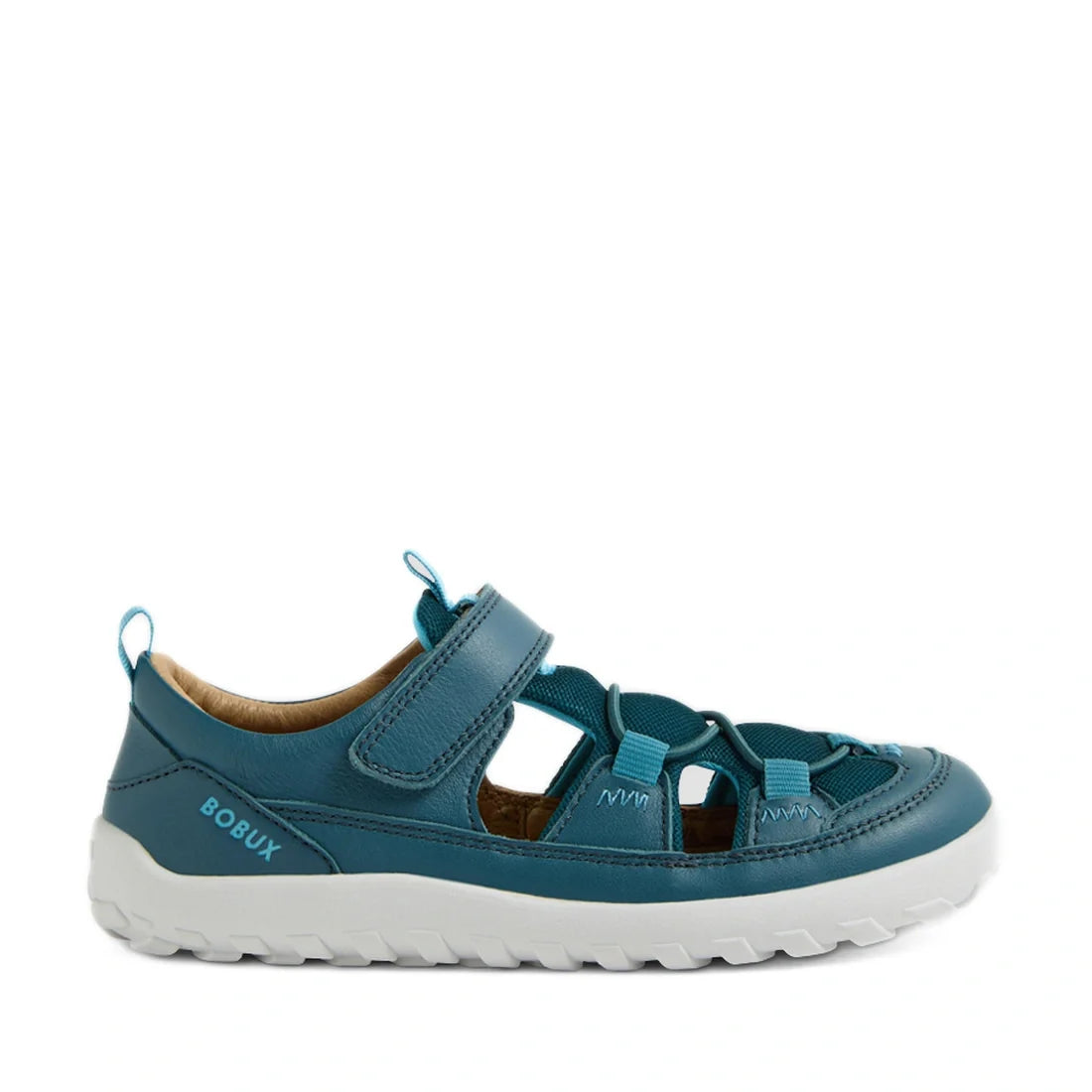 Introducing the Bobux Kid+ KP Rocky Leather Closed Toe Sandal in Mediterranean Green Barefoot—a stylish kids’ leather sandal featuring closed toes, cutouts for breathability, a secure hook-and-loop strap, a durable white rugged sole, and the BOBUX logo on
