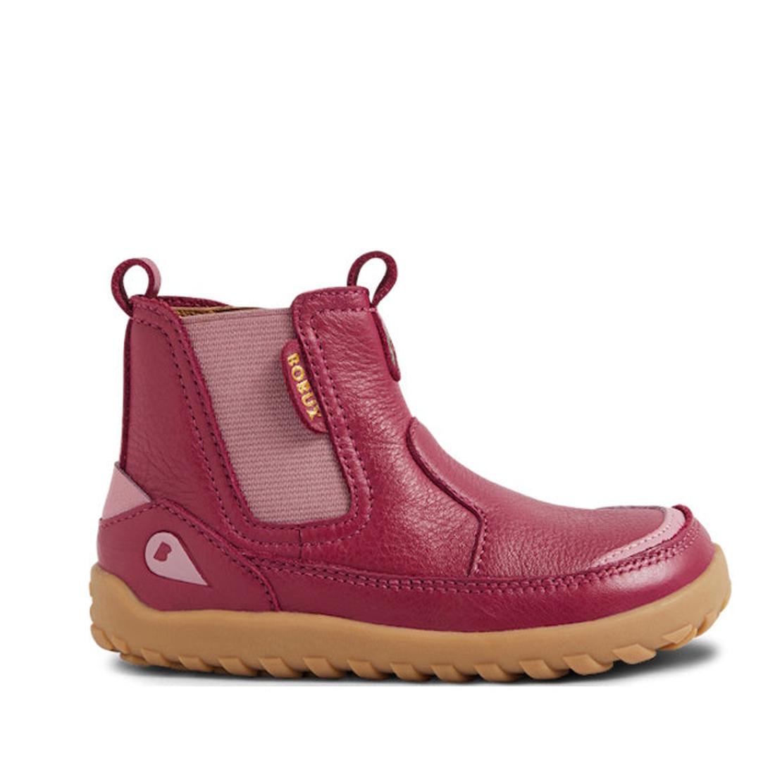 The Bobux KP Kids Plus Trail Leather Boot Juniors in Beaujolias Purple Alpha features a barefoot-shaped toe box, side elastic panel, pull tabs, tan zero drop sole, and a pink accent near the heel, shown in side profile on a white background., 942006856384