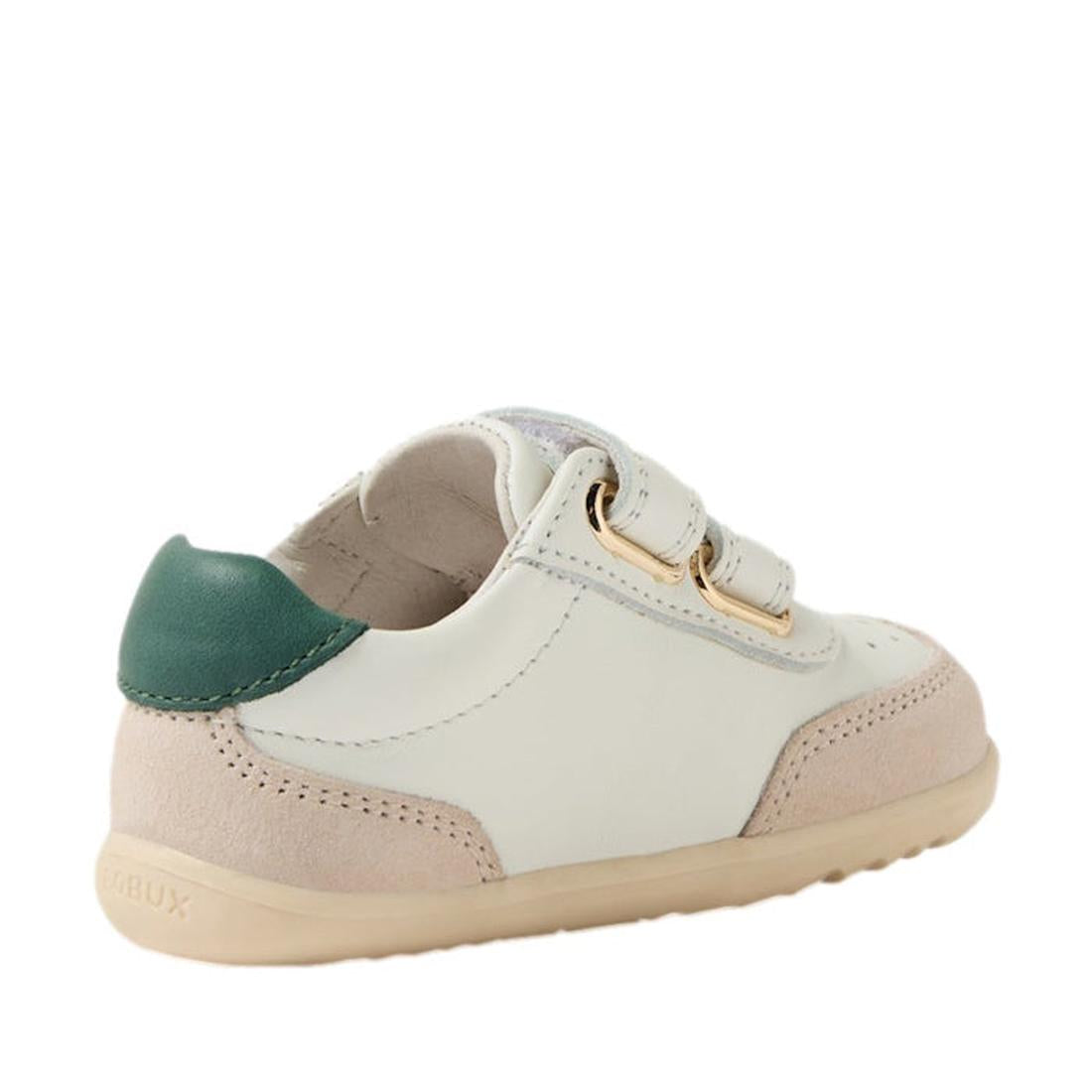 The Bobux Step Up SU Champ II Sneaker in Chalk White and Rainforest Green features a beige sole, white leather sides, light pink suede trim, green heel accent, and two velcro straps with gold loops. Shown from a rear-side angle., 9420074865441, 9420074865