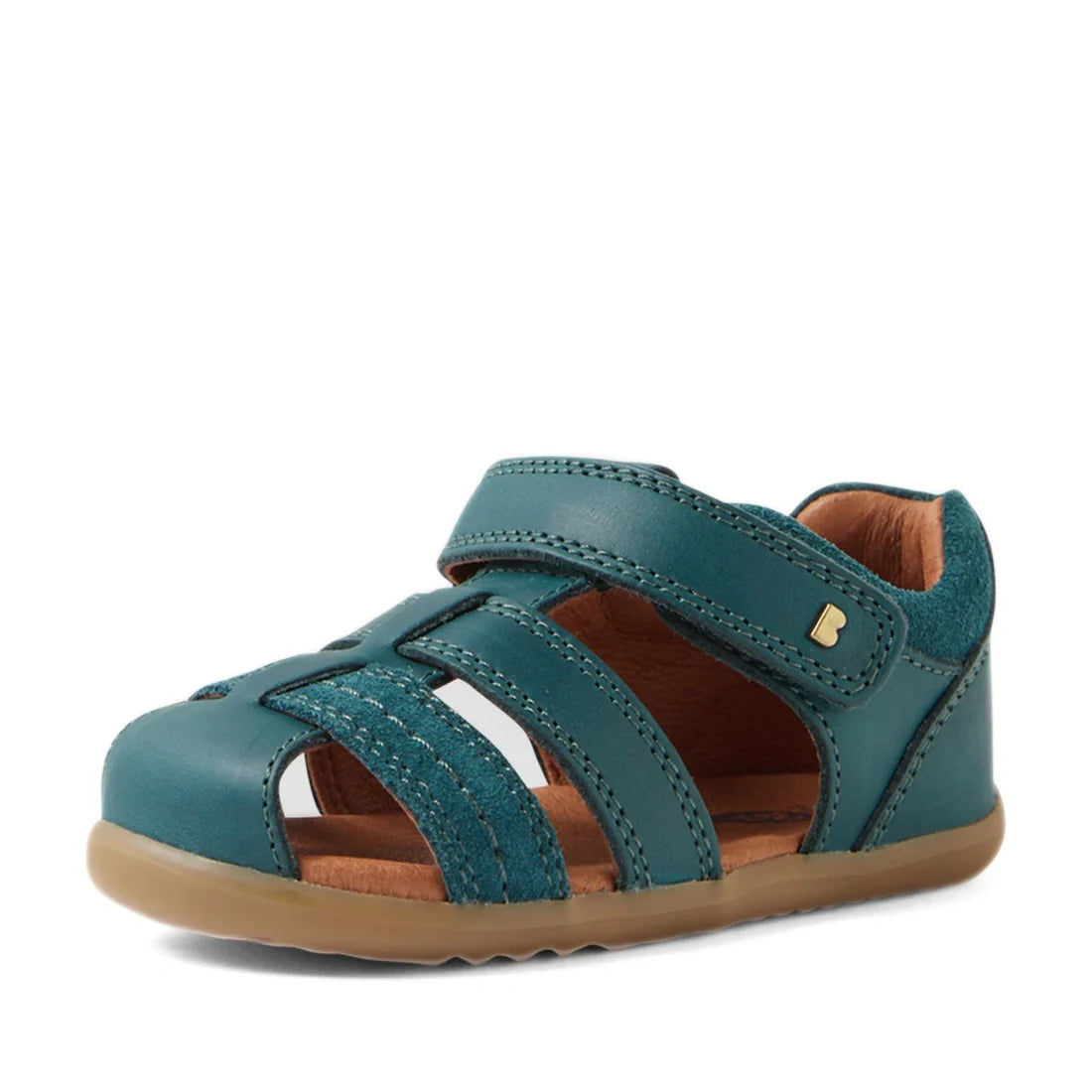 Introducing the Bobux Step Up Sandal Roam Closed Toe Sandals in Mediterranean Green—a leather sandal for children inspired by the classic Roam Toddlers design, featuring a closed toe, adjustable Velcro strap, open sides, tan interior, and a light brown ru