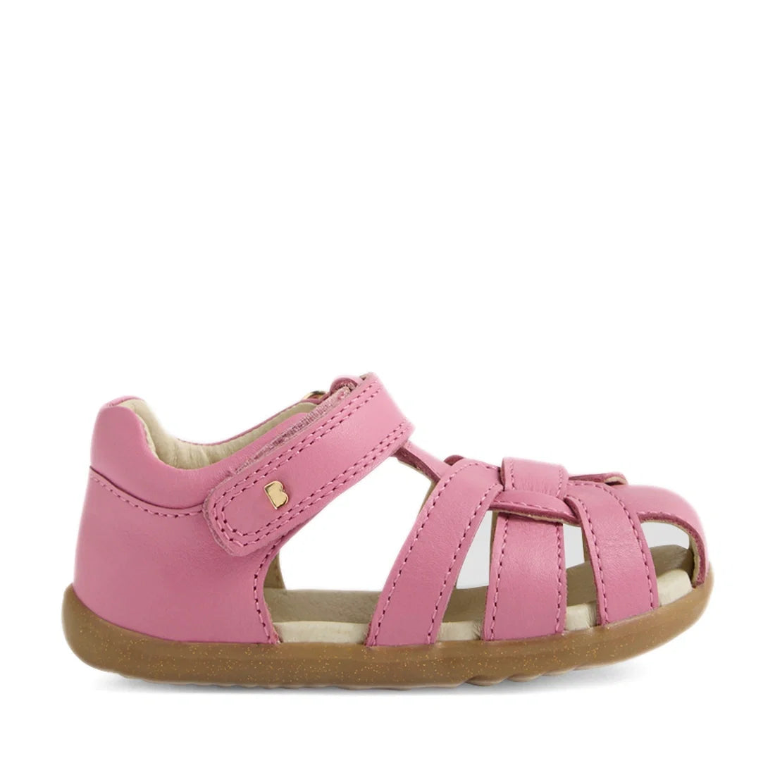 The Bobux Step Up Sandal Skip Twist Closed Toe Sandals in Cashmere Rose Pink feature a closed heel, open toe, multiple crossing straps with a velcro closure, and durable brown rubber soles—making them ideal first walking leather sandals for toddlers., 942