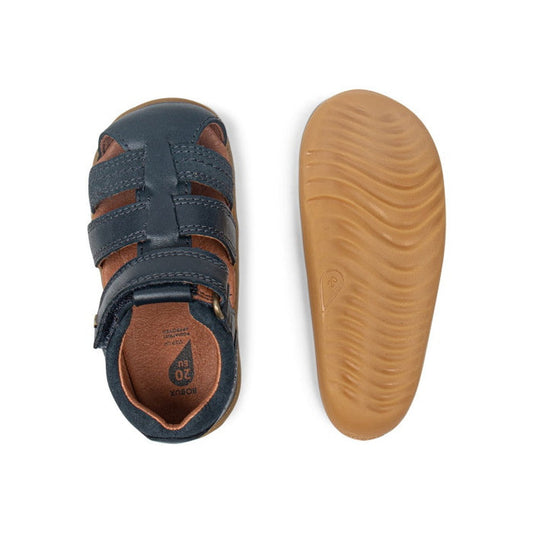 The Bobux Step Up Sandal Roam 729201A Navy Closed Toe for children is shown: one sandal displays brown and navy leather uppers from the top, while the other reveals a textured light brown rubber sole from the bottom., 9420057332076, 9420057332083, 9420062