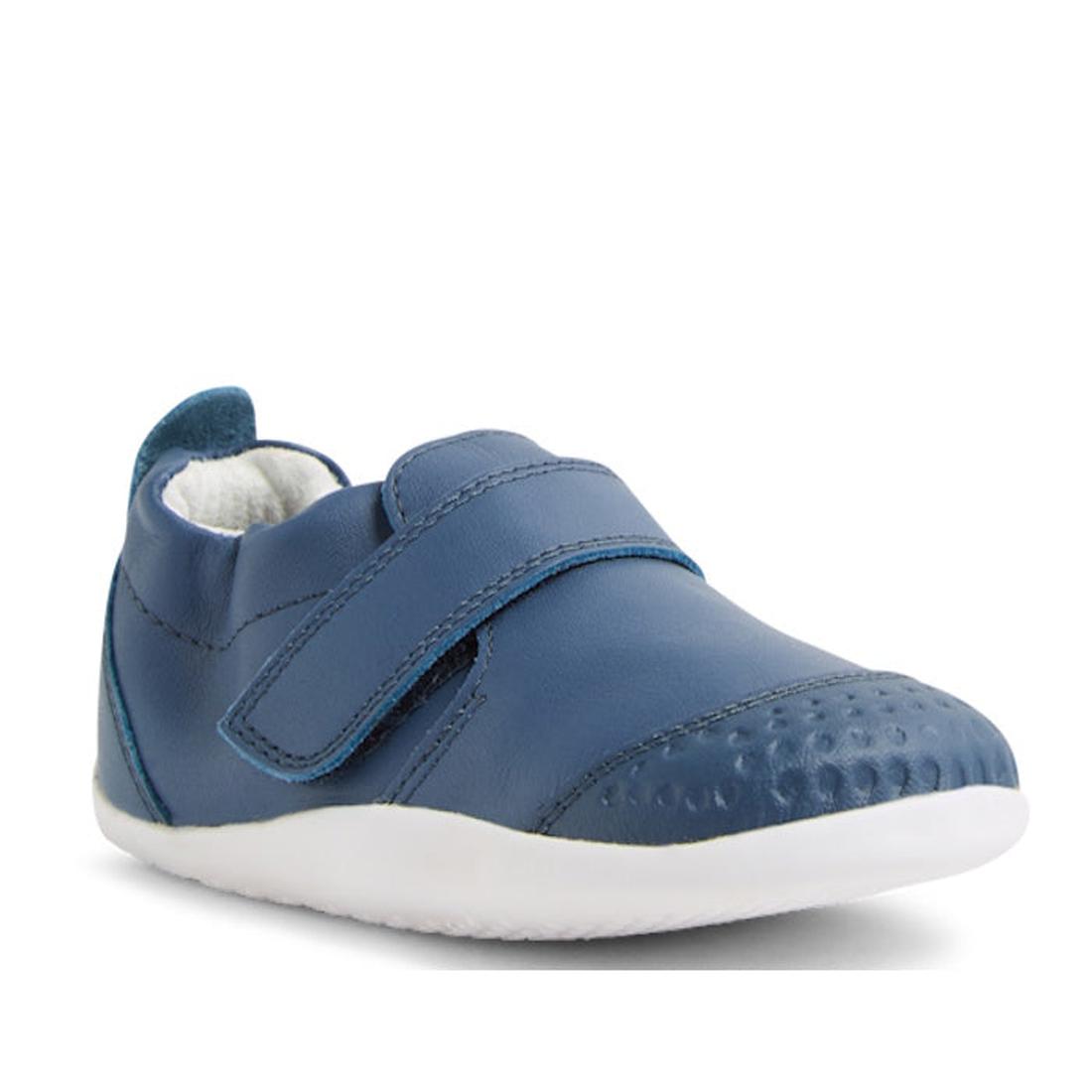 The Bobux XP Xplorer First Walking Shoes Go Vintage Indigo Blue is a single pre-walker leather shoe with a textured toe, Velcro strap, white interior, and flexible white rubber sole—perfect for first steps., 9420074842657, 9420074842664, 9420074842671, 94