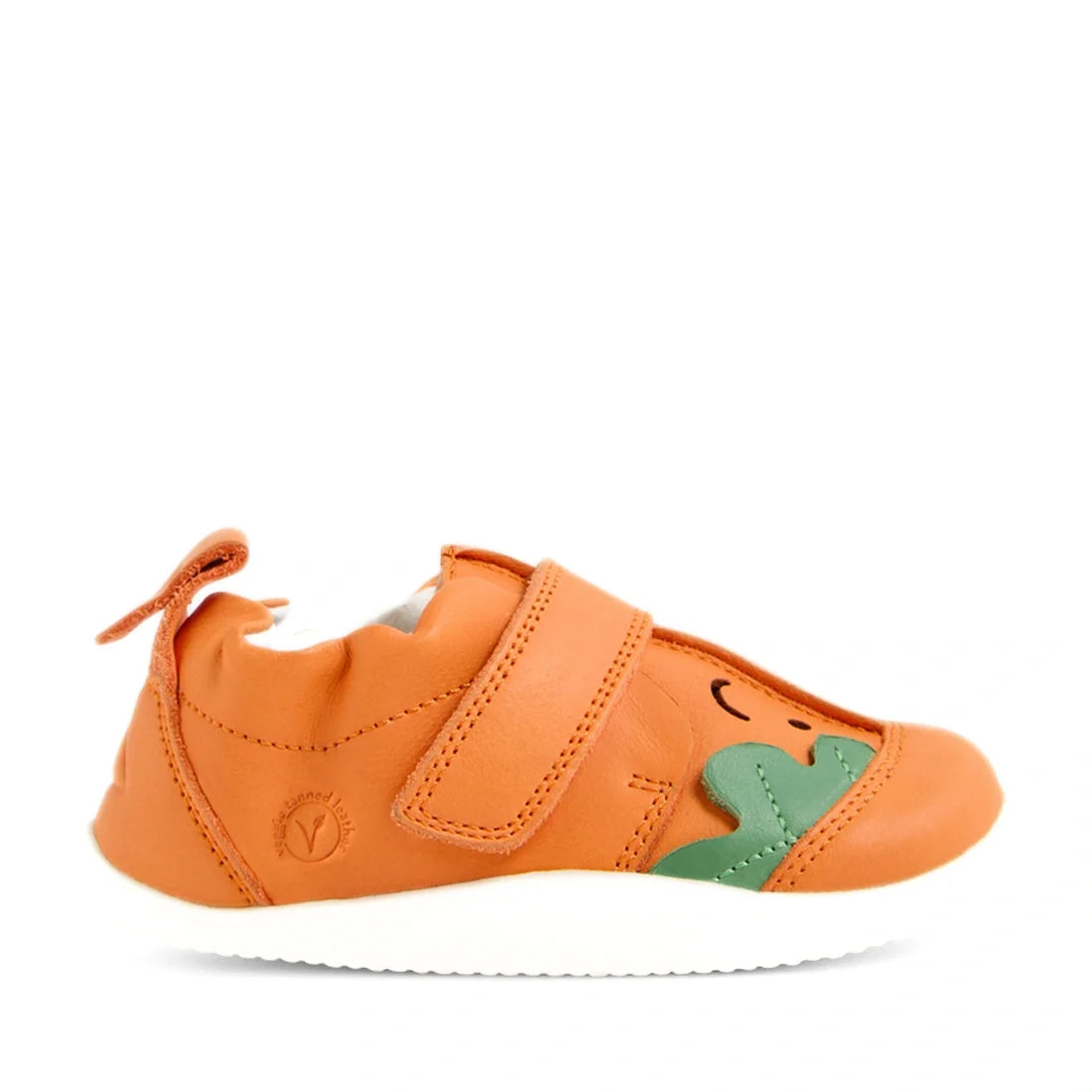Introducing the Bobux XP Explorer Little Sprouts Carrot Top First Walker Orange: a vibrant orange baby shoe featuring a white sole, green leafy accent, cheerful smiling face design, and secure hook-and-loop strap closure. These first walking shoes offer a