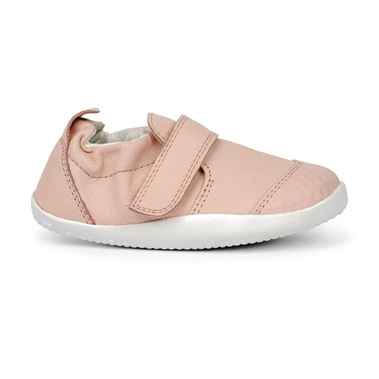 The Bobux Explorer Go Seashell Pink First Walker Crawler 501011B features a soft pink design with a white sole, textured toe for protection, Velcro strap for easy fastening, pull tab at the back, and is made for comfort., 9420062080238, 9420062080214, 942