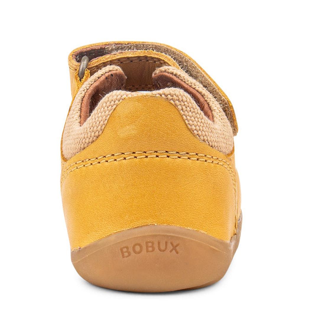 A close-up rear view of the Bobux Step Up SU Driftwood Toddlers Sandal in Chartreuse Yellow, featuring a brown sole, “BOBUX” embossed on the heel, a soft collar, premium leather details, and a Velcro strap., 9420062001387, 9420057330690, 9420057330706