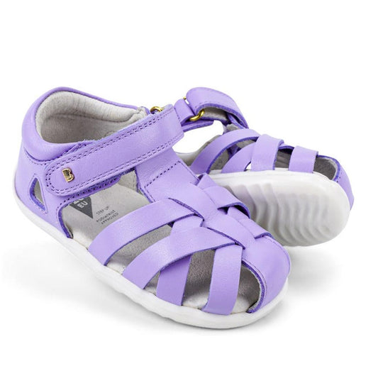 The Bobux Step Up Tropicana II Lilac Toddler Girls Sandal 732315 features a quick-dry design, closed toes, open sides, white rubber soles, and a Velcro ankle strap—perfect for kids.