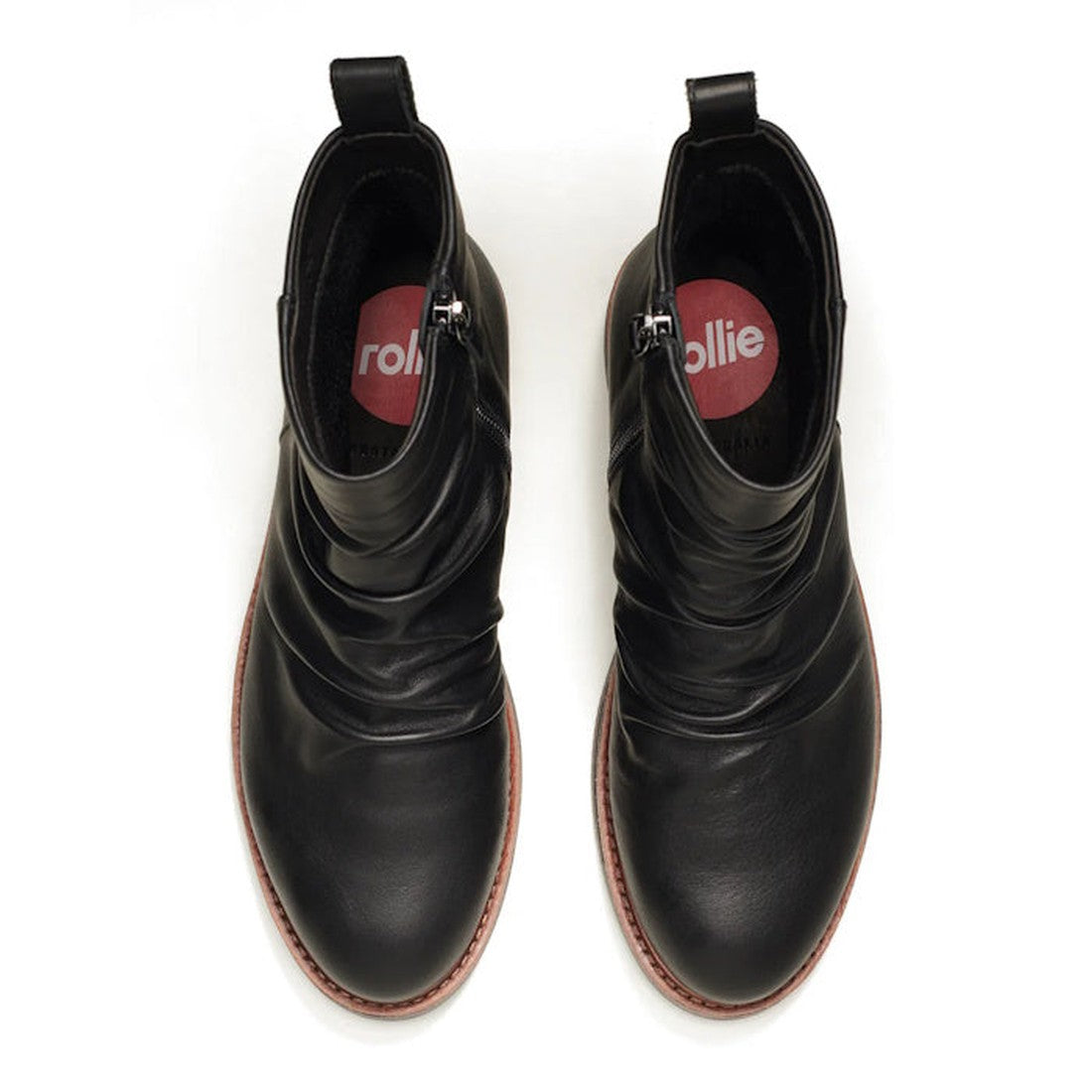 A top-down view of Rollie Womens Ankle Black Leather Boot Side Zip Rise Artisan, featuring metal side zips, brown Vibram outsoles, and red insoles with "rollie" in white., 9339554339214, 9339554339221, 9339554339238, 9339554339245, 9339554339252, 93395543