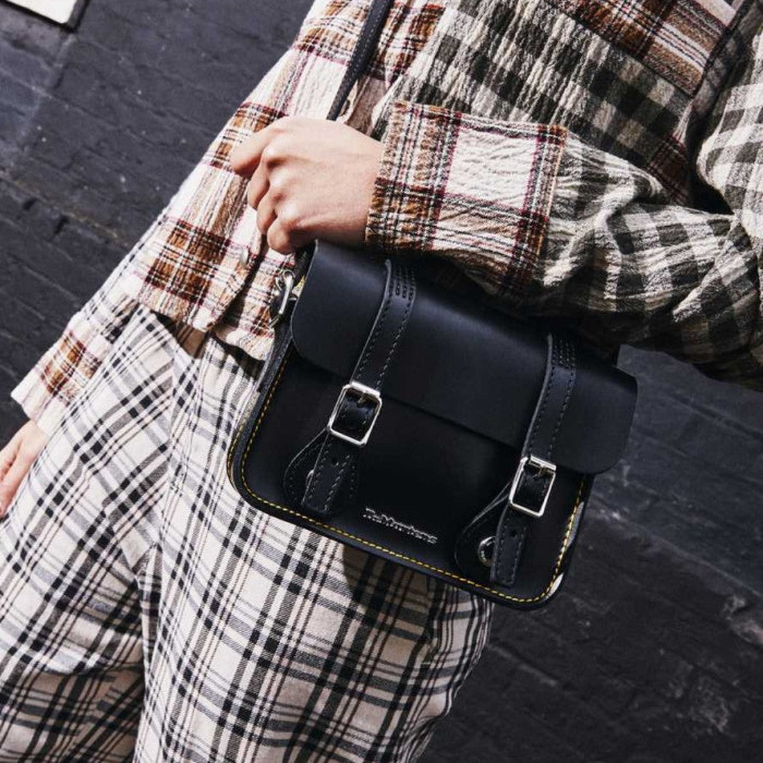 A parent shows the Dr Martens Leather Cross Body Black Satchel 7", with sturdy sole, silver buckles, and easy magnetic closure.  ksnz, 190665191974