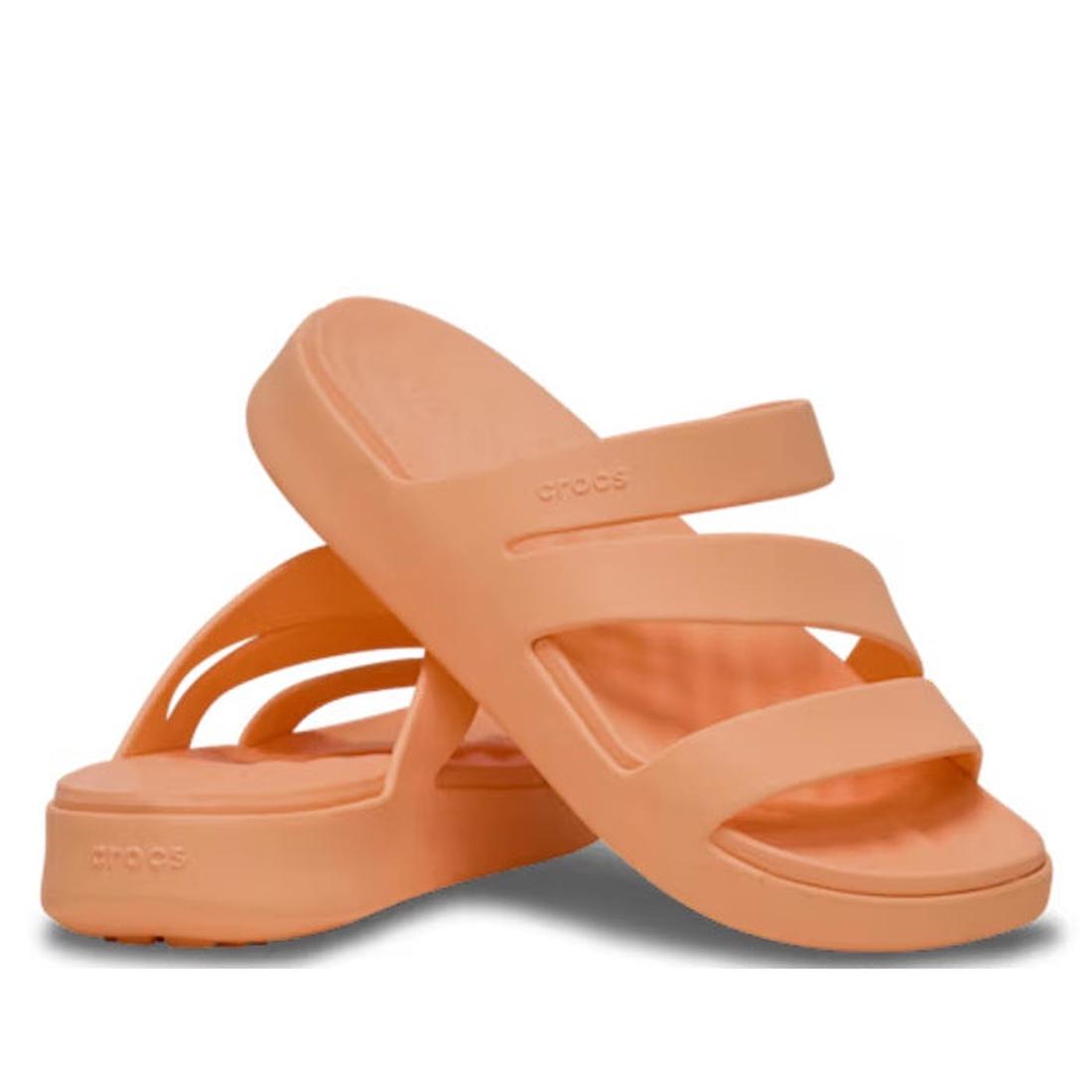 A pair of Crocs Women's Getaway Strappy Slide Sandals in Electric Sunstone Orange, featuring three straps and a thick, contoured sole with Free Feel Technology. One sandal stands upright; the other is tilted and leaning against it.