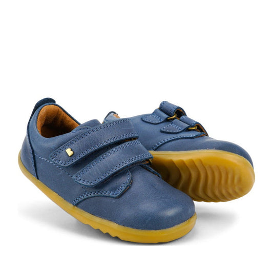 The Bobux Step Up Port Shoe Midnight Blue727718 are children’s blue leather shoes with yellow rubber soles and double Velcro straps, ideal first walkers, shown on a white background.