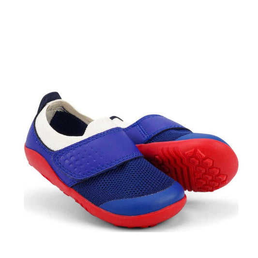 The Bobux Step Up SU Dimension III Blueberry First Walker features blue mesh uppers, Velcro straps, white ankle lining, and a red lightweight sole. One shoe is upright; the other is tipped to display the sole and toe protection. CLEARANCE—Not Returnable.