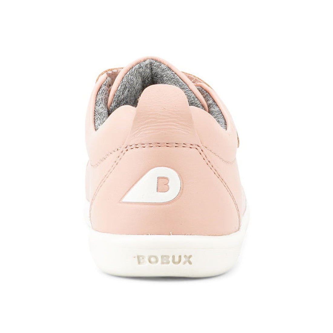 A close-up rear view of the Bobux KP Kid Plus Grass Court Seashell Pink 832448 kids trainer shows a pale pink leather upper, white sole, gray lining, double velcro straps, a white B logo on the heel, and BOBUX text on the back., 9420075792579, 94200757930