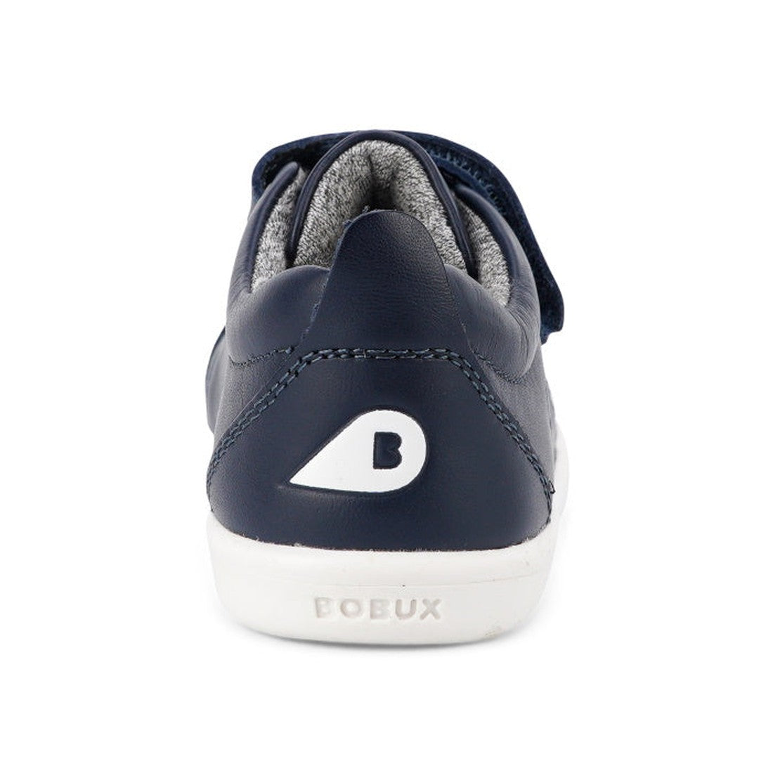 A back view of the Bobux Iwalk Grass Court Navy Leather Trainer 633723J shows its navy blue upper, white sole with "BOBUX" embossed, and a white "B" logo on the heel., 9420075792548, 9420075791404, 9420075792227, 9420075792784, 9420075793286