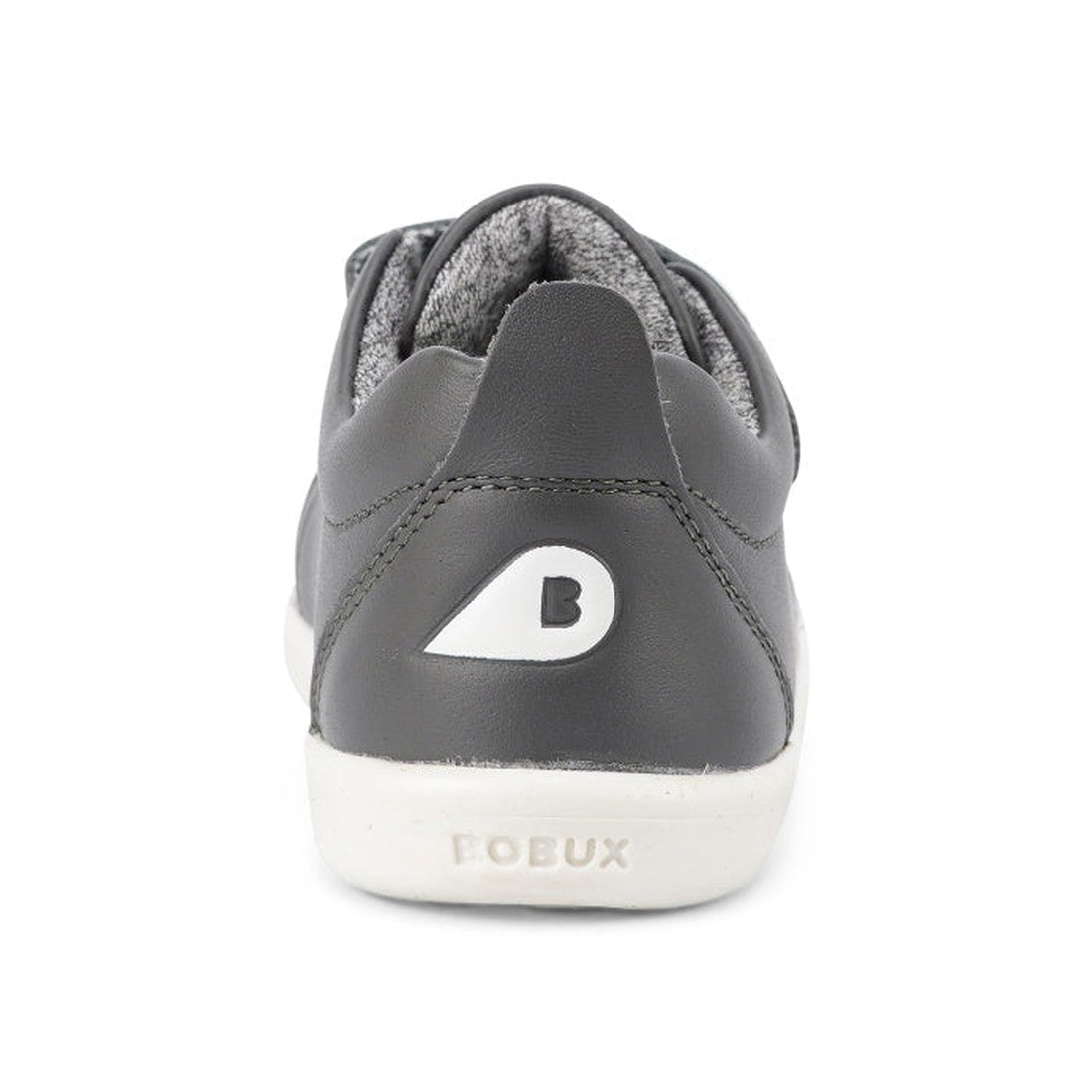 A rear view of the Bobux Iwalk Grass Court Smoke Grey Leather Trainer 633702 shows its unisex gray leather design with a white sole, a “B” on the heel, “BOBUX” embossed on the back, and a soft gray interior—perfect as a casual kids’ sneaker., 942006851797
