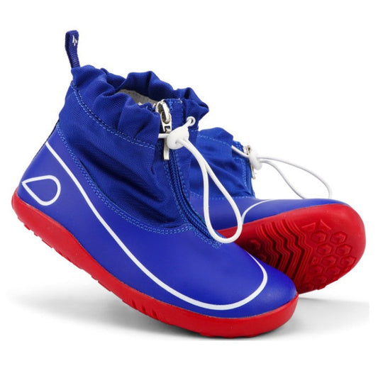 The Bobux Kid+ Splash Boot Waterproof Blueberry 839003 features blue waterproof design, red soles, white detailing, and white elastic toggle closures for easy slip-on—perfect everyday shoes for adventurous kids.