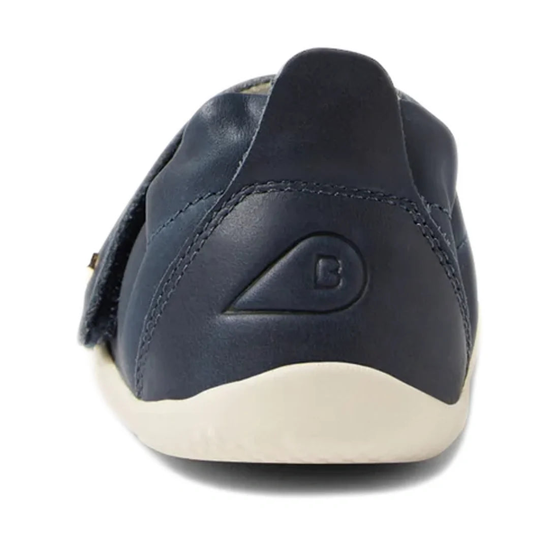 Sure! Here’s a revised version of your sentence using the provided product data: The Bobux XP Explorer Ripple First Walker Navy 502509 is shown from the back, featuring navy blue leather, a white flexible sole, and a raised B logo inside a semicircle on t