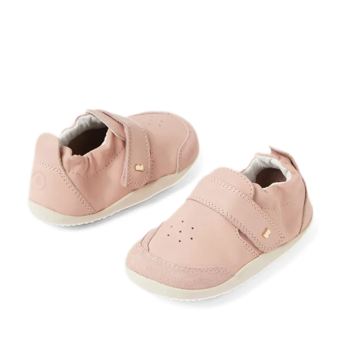 A pair of Bobux XP Explorer Ripple First Walker Cameo Rose 502603 baby shoes in soft pink (Cameo Rose), featuring flexible soles, white accents, velcro straps, and subtle gold embellishments, displayed side by side on a white background—perfect as stylish