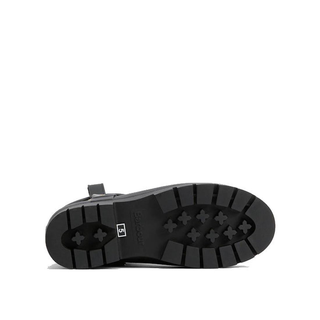 The image displays the black rubber sole of a Barbour Elley Harness Black Wellington Womens Rainboot on its side, featuring a chunky tread pattern with rectangular and cross-shaped grips against a plain white background., 5020985983018, 5020985983575, 502