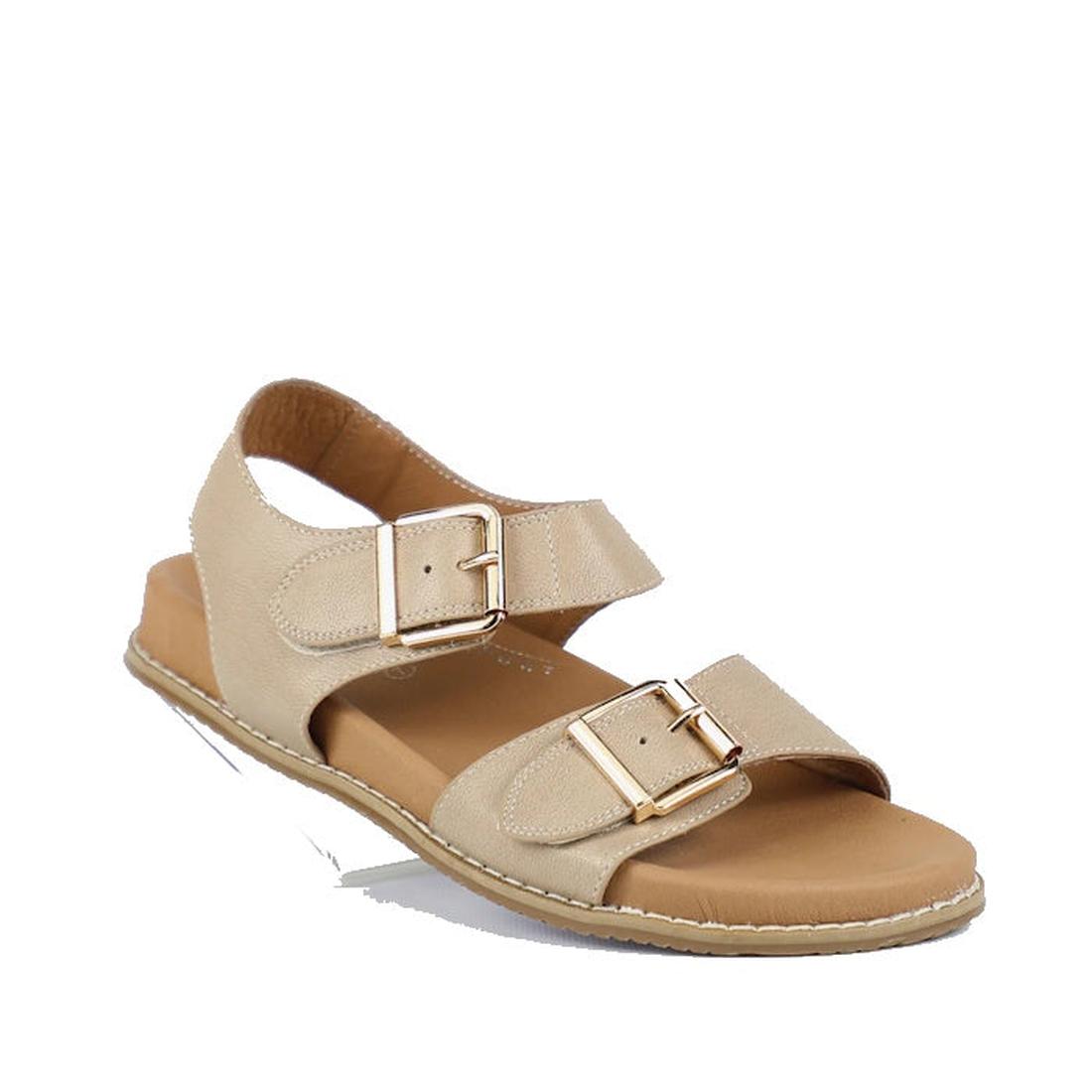 Bay Lane Zeus Latte Womens Leather Sandal with back strap features two adjustable gold buckles on wide straps, a cushioned footbed, and a low flat sole—crafted for comfort and style, shown on a white background.