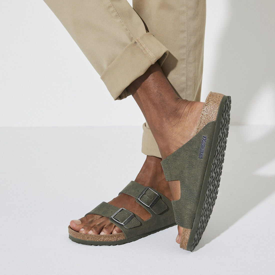 Person wearing birkenstock vegan green sandals 2 strap slides with a white background.,4061418353306,
4061418353344,
4061418353382,
4061418353429,, 49322, 49323, 49324, 49325, 4061418353306, 4061418353344, 4061418353382, 4061418353429