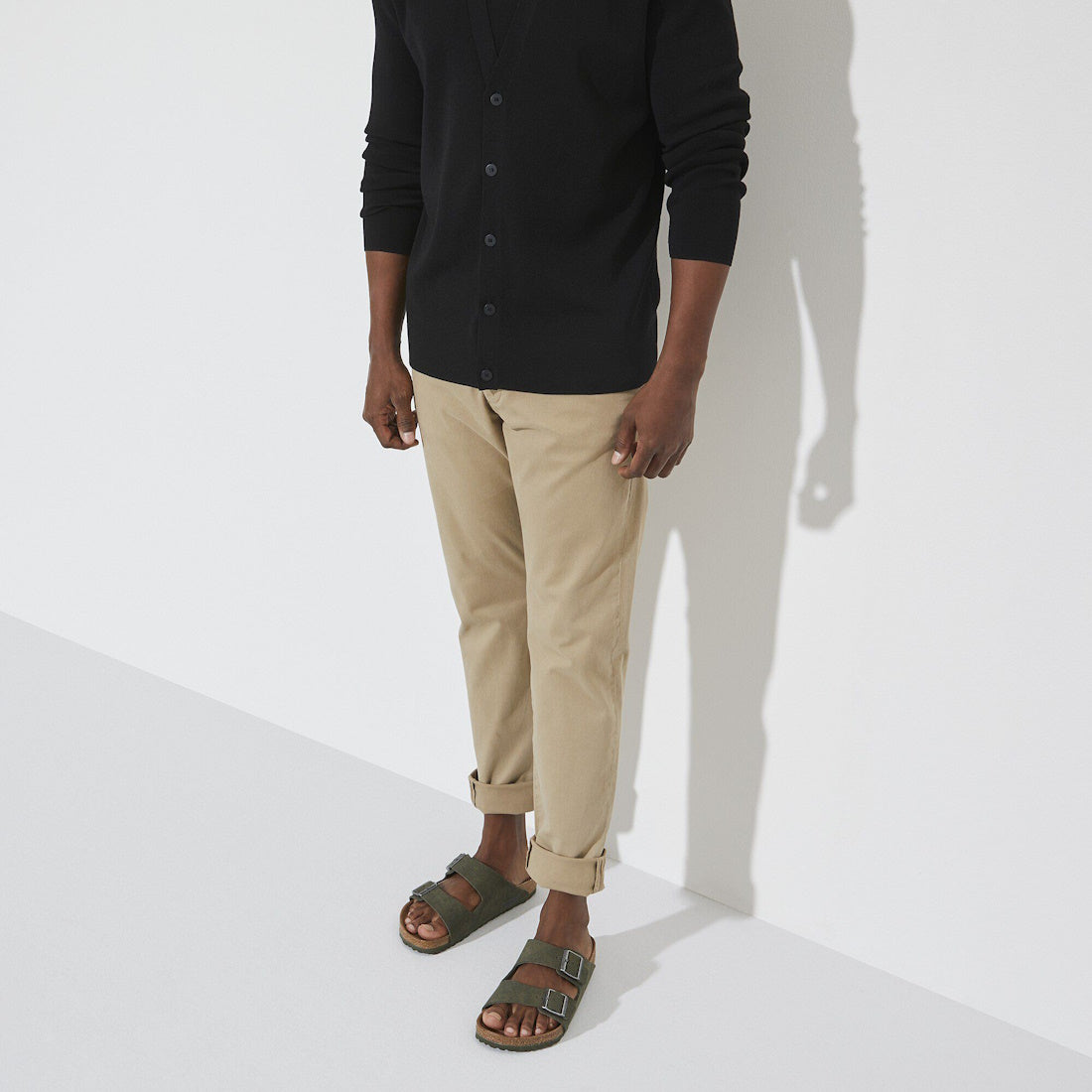 Person wearing a black shirt, beige pants, and desert dusk thyme green arizona bikenstock vegan sandals on a white background.,4061418353306,
4061418353344,
4061418353382,
4061418353429,, 49322, 49323, 49324, 49325, 4061418353306, 4061418353344, 406141835