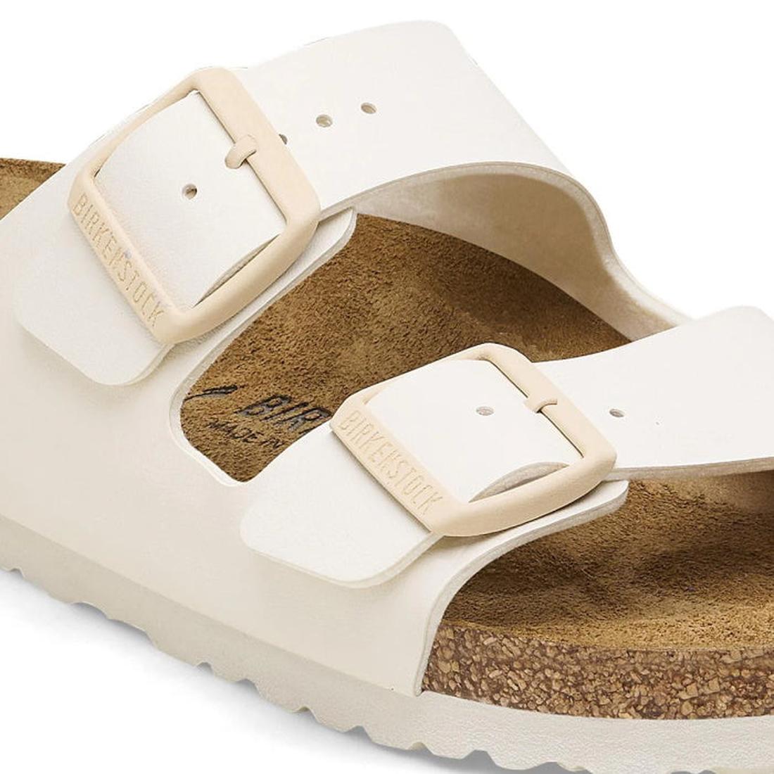 Beige sandal with a buckle on a white background close up strap and buckle dtail of Birkenstock arizona eggshell slide sandal.
4066648369509,
4066648369547,
4066648369585,, 46716, 46717, 4066648369509, 4066648369547, 4066648369585, 46721, 46722, 46723, 46