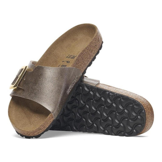 A pair of Birkenstock Womens Catalina Cushion Buckle Birko Flor sandals in graceful taupe (regular width), featuring a single strap, cork-latex footbed, textured outsoles, and a large gold buckle. One sandal rests on its side atop the other showing the so
