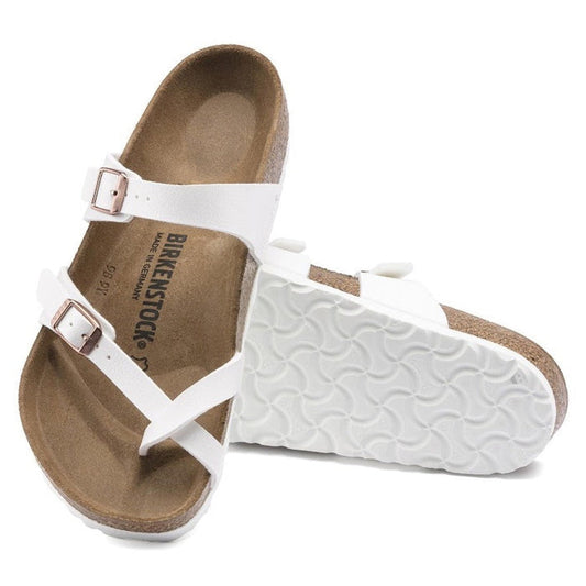 A pair of Birkenstock Mayari Womens Birko Flor sandals in white with a regular width, featuring two straps with buckles, a contoured footbed, and brown sole. One sandal stands upright while the other lies on its side.