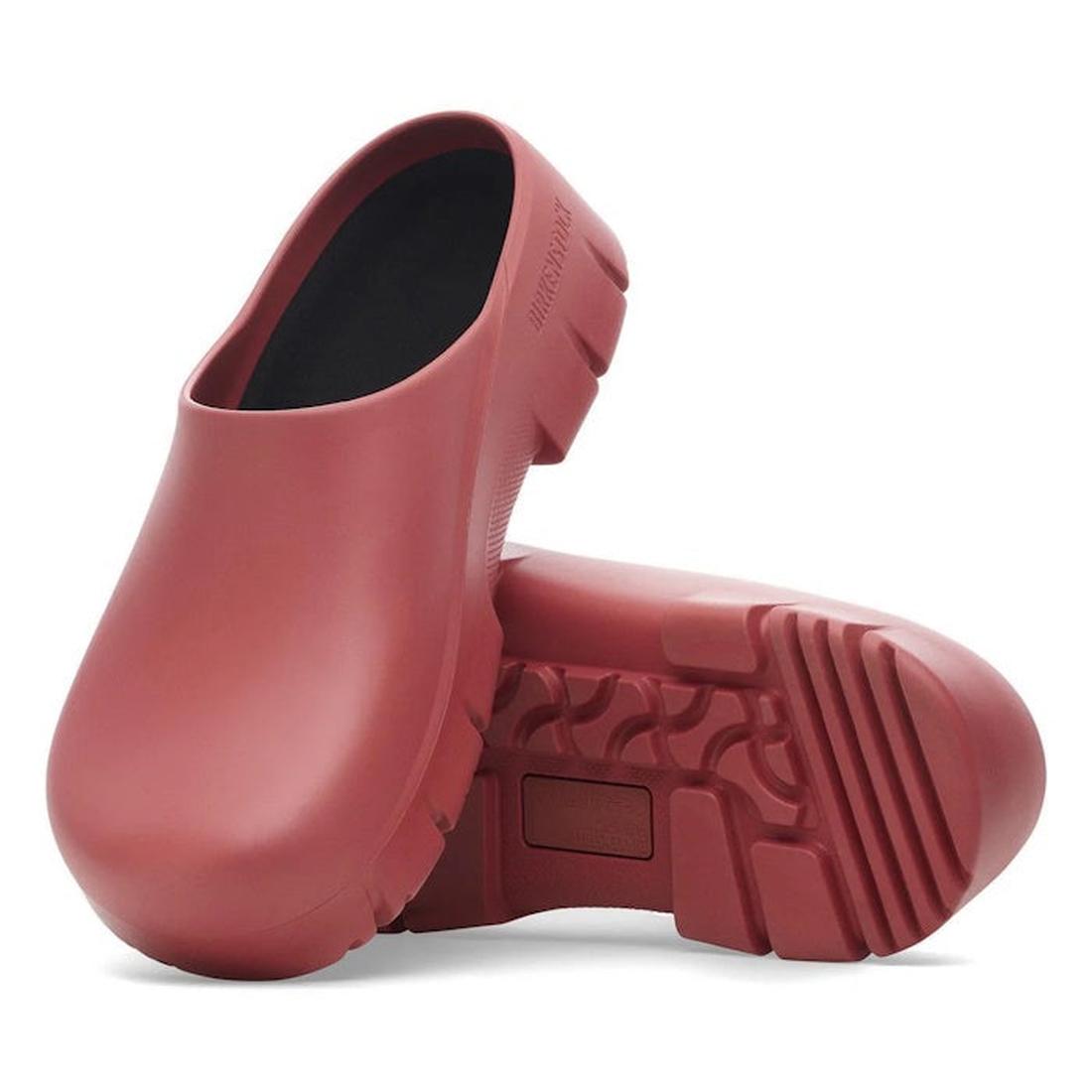 A pair of BIRKENSTOCK Super Birki 2.0 Polyurethane clogs in Mars Red, regular width, featuring chunky, textured soles—one upright and the other on its side to highlight the slip-resistant tread pattern.