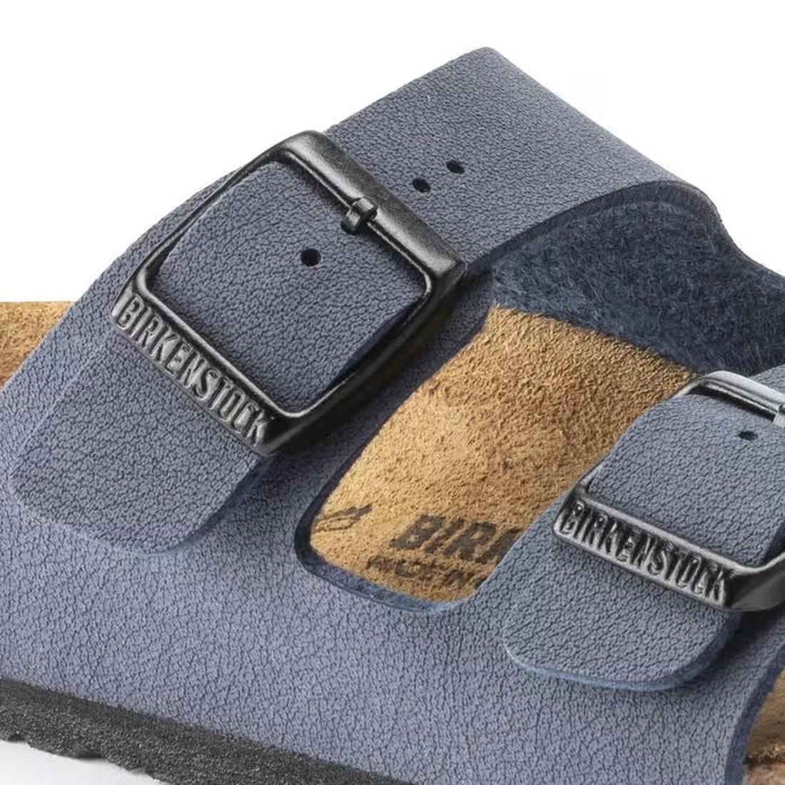 Close-up of Birkenstock Kids Arizona Navy Birkibuc Narrow Slides, featuring two adjustable navy straps with metal buckles and a tan cork-latex footbed., 47504, 47505, 47506, 47507, 4052001281762, 4052001281779, 47510, 4052001281793, 47512