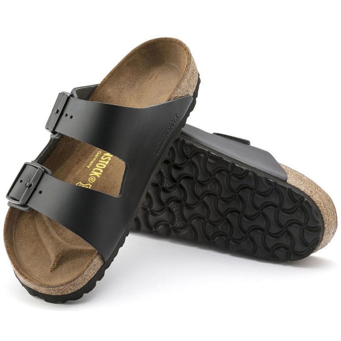 a pair of Birkenstock Arizona Smooth Leather Black Narrow Width with double straps, one over the foot and one over the toes with buckle adjustment. Staps are linked at the sides of the foot. Leather thick straps and a suede leather footbed,