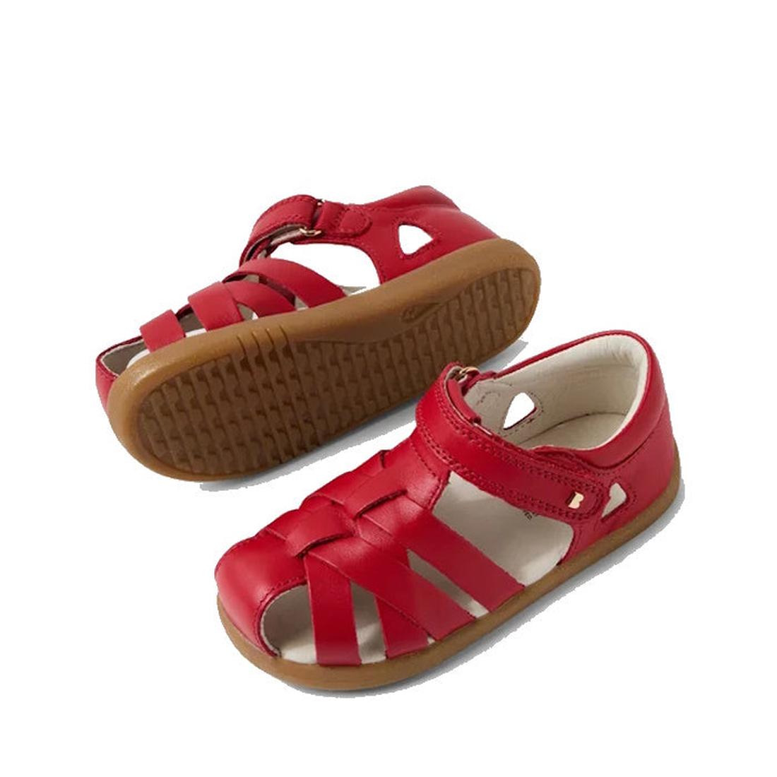 The Bobux Iwalk IW Tropicana II Salsa Red Leather Sandal is a toddler shoe with an enclosed toe, cut-out sides, brown rubber sole, and hook-and-loop ankle strap, shown on a white background., 9420074811202, 9420074811219, 9420074811226, 9420074811233, 942
