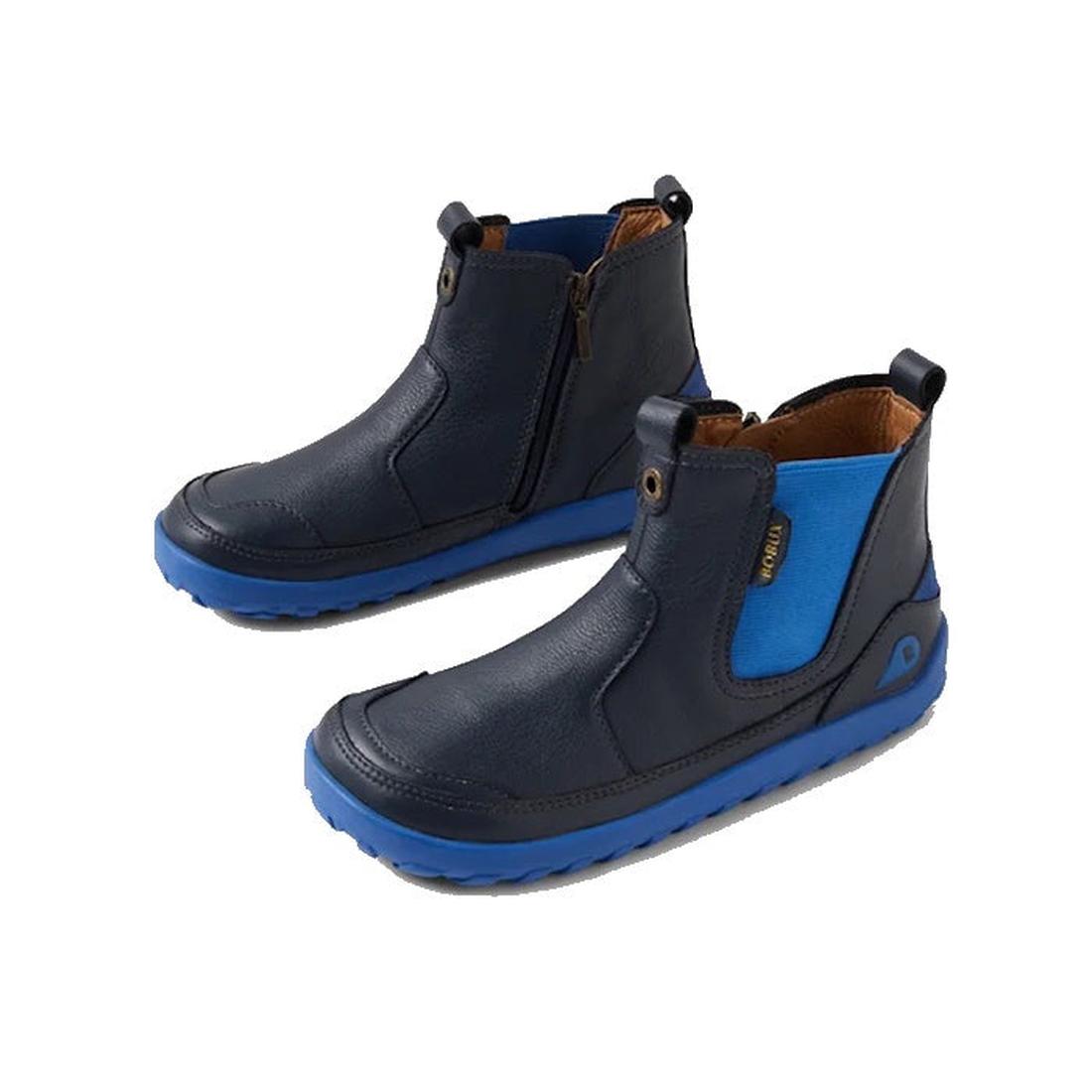 The Bobux KP Kids Plus Trail Navy Leather Boot Juniors Alpha features bright blue elastic side panels and soles, a barefoot-shaped toe-box, side zippers, and back pull tabs for easy on and off.
