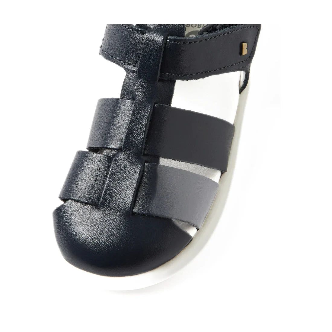 Close-up of the Bobux IWalk Tidal Closed Toe Quick Dry Sandal in Navy (634404A), made from Quick Dry Leather, featuring a navy blue closed toe design with three horizontal straps over the toe and a white sole, photographed against a white background.