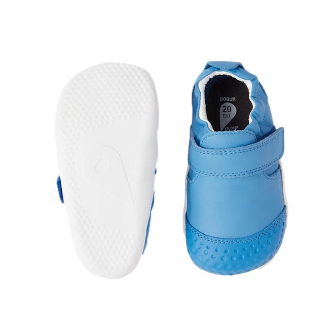 The Bobux Explorer Go First Walking Trainer in Azure Blue features a soft leather upper, hook-and-loop strap, and flexible white sole; one shoe is shown from the top and the other highlights the textured bottom., 48682, 9420068567900, 9420068567917, 94200