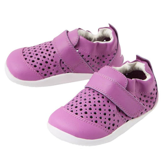 A pair of Bobux Xplorer Go Punch Orchid Purple First Walker Sandals featuring bright purple perforated uppers, white soles, Velcro straps, and a lightweight flexible outsole—beautifully displayed on a white background.