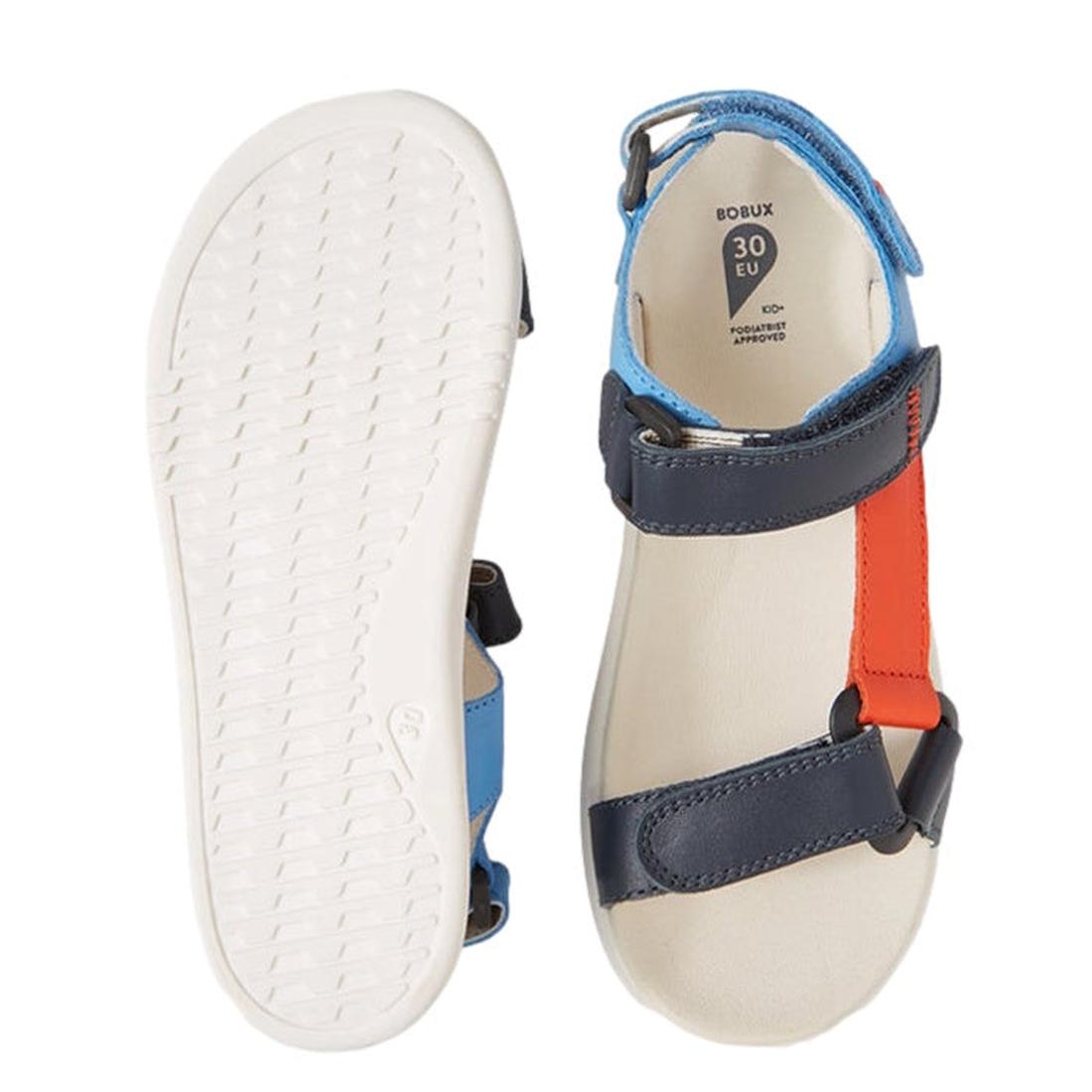The Bobux Kid+ Plus Vine Leather Navy Open Toe Sandal Junior features water-friendly leather, navy with red and light blue straps, a white sole, an adjustable strap for a secure fit, and an open toe design perfect for kids., 9420074820358, 9420074820365, 