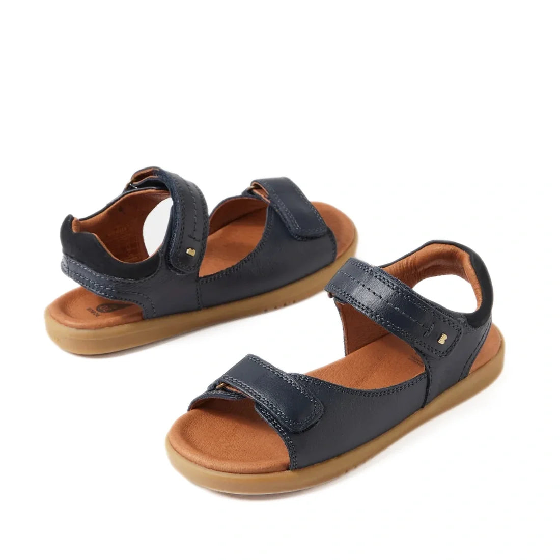 Certainly! Here’s a rewritten version of your sentence using the provided product data: Two pairs of Bobux Kid+ Plus Driftwood Navy Open Toe Sandal 833501AA feature navy blue leather straps and brown cushioned insoles for all-day comfort. These kids’ sand