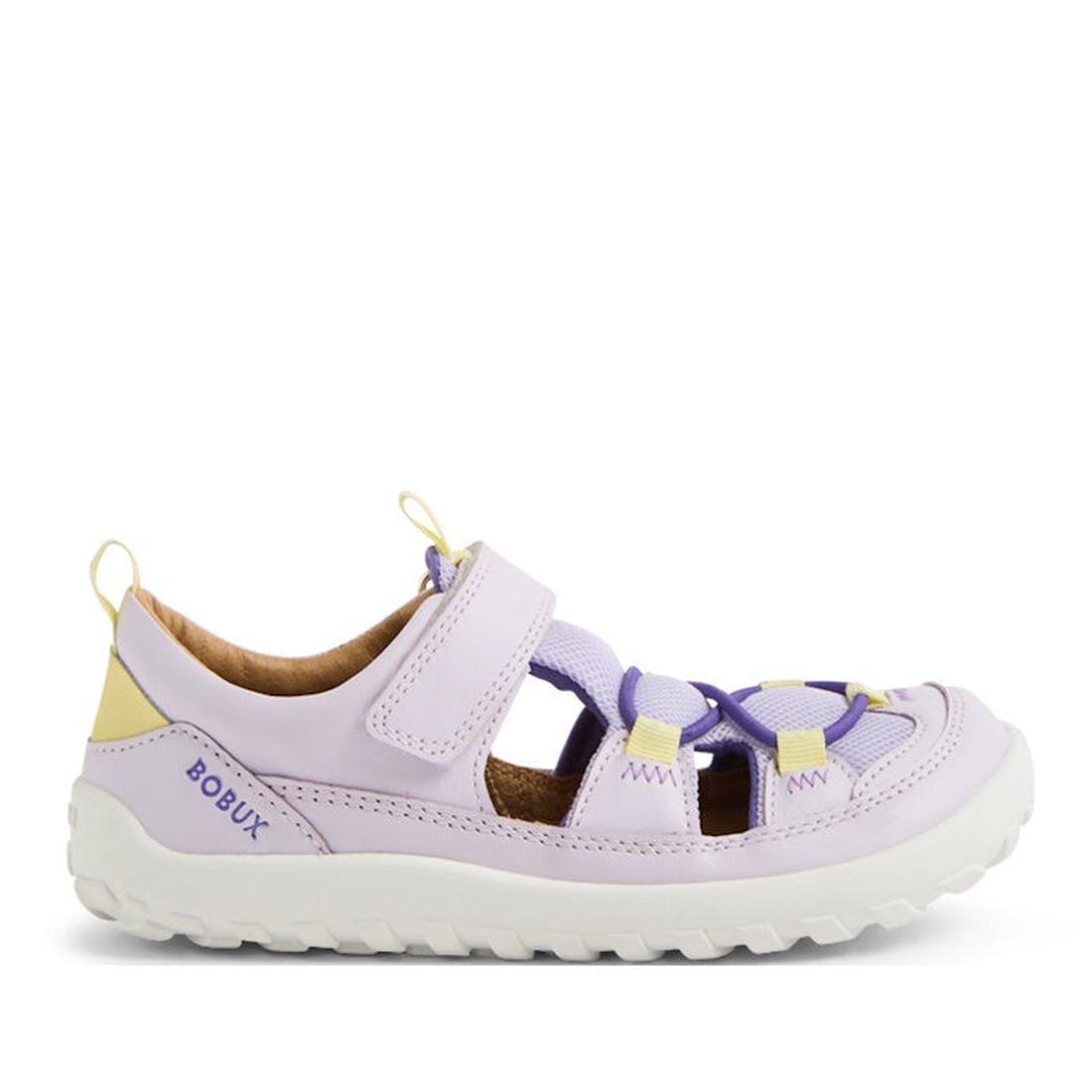 The Bobux Kid+ Rocky Leather Closed Toe Sandal in Thistle Lavender is a children’s sandal with yellow accents, velcro strap, breathable leather upper, rugged white sole, and “BOBUX” branding on the heel.