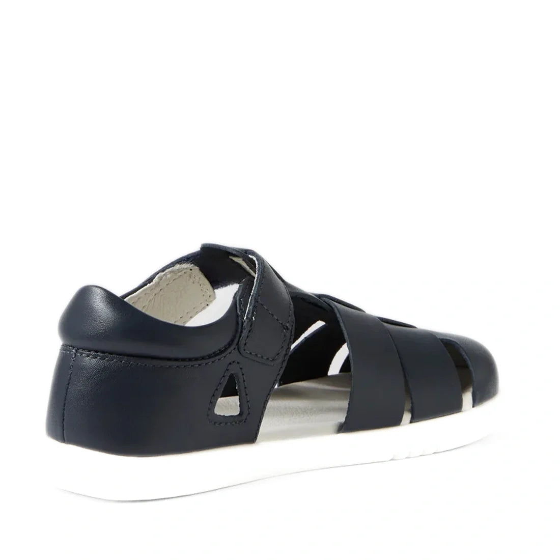 The Bobux Kid+ Plus Tidal Closed Toe Quick Dry Sandal Navy 834404A is shown from the back, featuring a navy blue design with a closed heel, open sides, and a contrasting white sole. This sandal has a closed toe, secure Velcro strap, and multiple horizonta