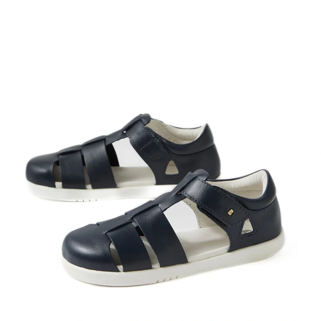 A pair of Bobux Kid + Plus Tidal Closed Toe Quick Dry Sandals in navy (style 834404A), featuring closed toes, white soles, and velcro straps, crafted from quick dry leather, displayed on a white background.