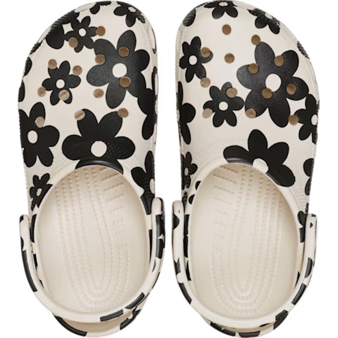 A pair of Crocs Adults Classic Pop Petals Summit White Multi clogs with black and dark gray floral patterns, viewed from above. These shoes feature ventilation holes—perfect for adding customizable Jibbitz charms—and come with adjustable heel straps for s