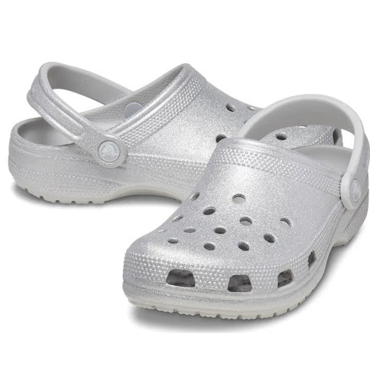 The Crocs - Classic Clog Adults Silver Glitter features ventilation holes, textured soles, and adjustable heel straps—stylish, comfortable, and ideal for any occasion. Displayed on a white background.