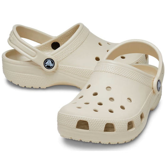 Crocs Kids Classic Clog in Bone—youth sizes, comfy slip-on shoes with airy holes, sturdy sole, and secure heel strap on white.  ksnz