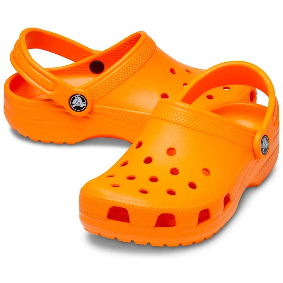 A pair of bright orange Crocs Kids Classic Clog Orange Zing for junior youths, featuring ventilation holes and adjustable heel straps. Lightweight and water-friendly, perfect for everyday adventures. Displayed on a white background.